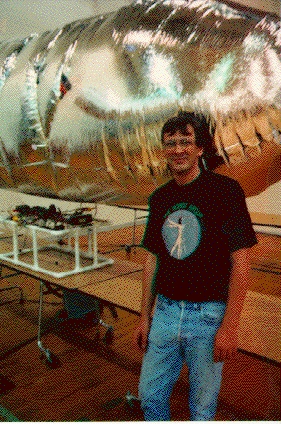 Bill Craig, charter member, standing in front of one of the blimps